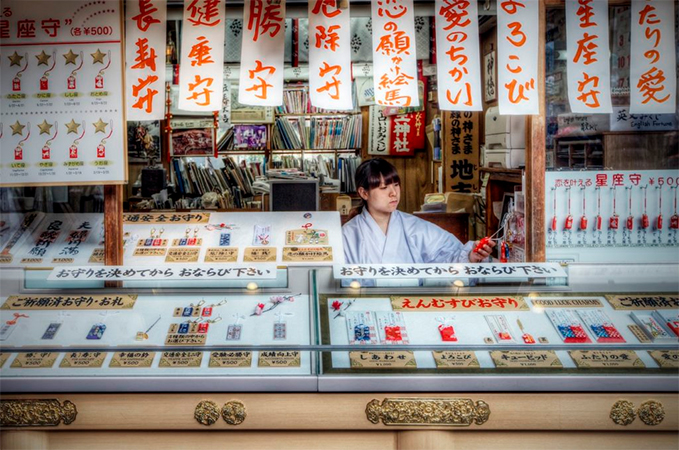 Woman selling omamori at a temple or shrine