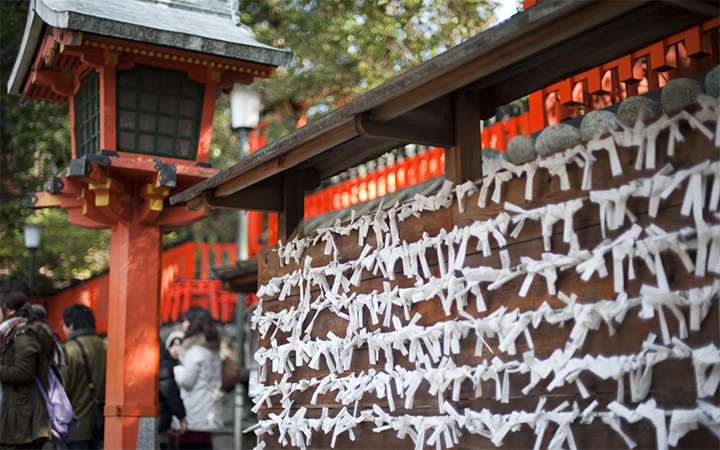 Omikuji (paper fortunes) left on a wooden board at a temple or shrine
